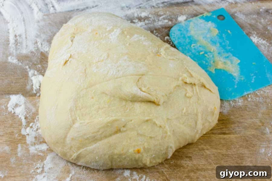 Panettone dough on a wooden board with a light dusting of flour.