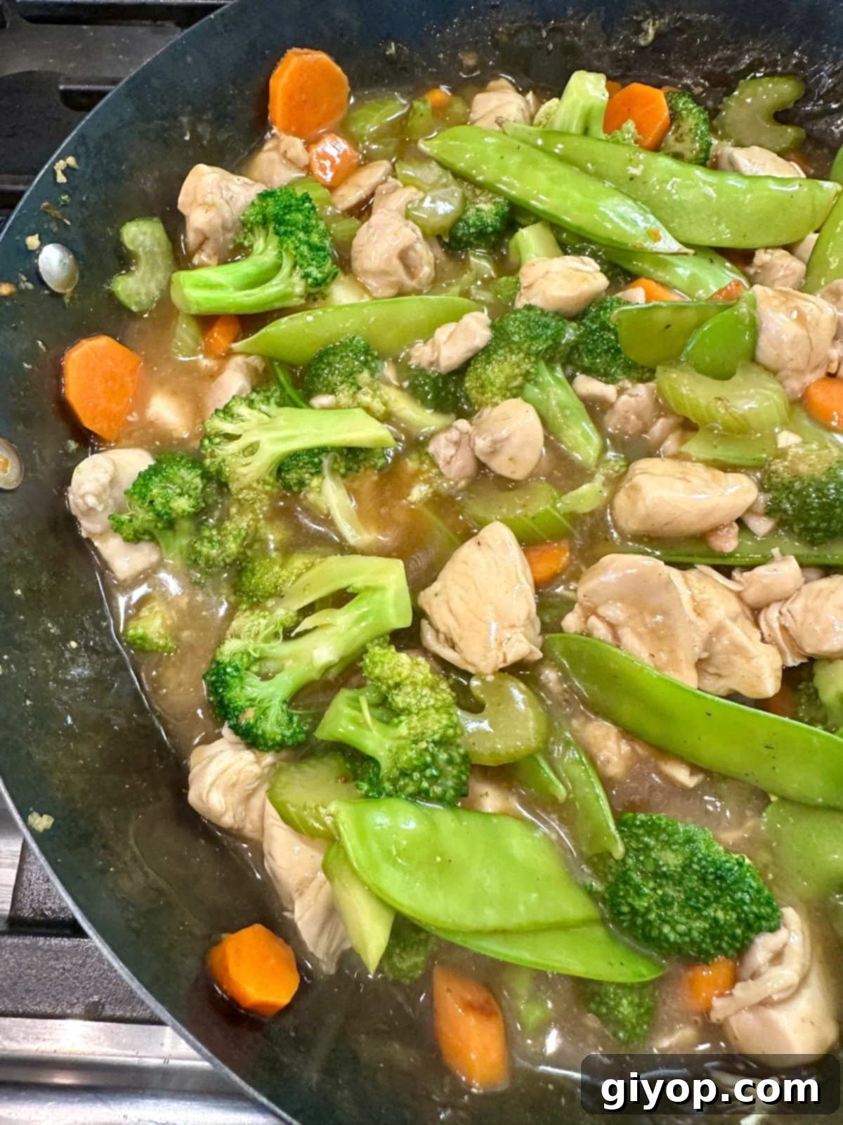 Veggies for cashew chicken stir fry with chicken in a pan.