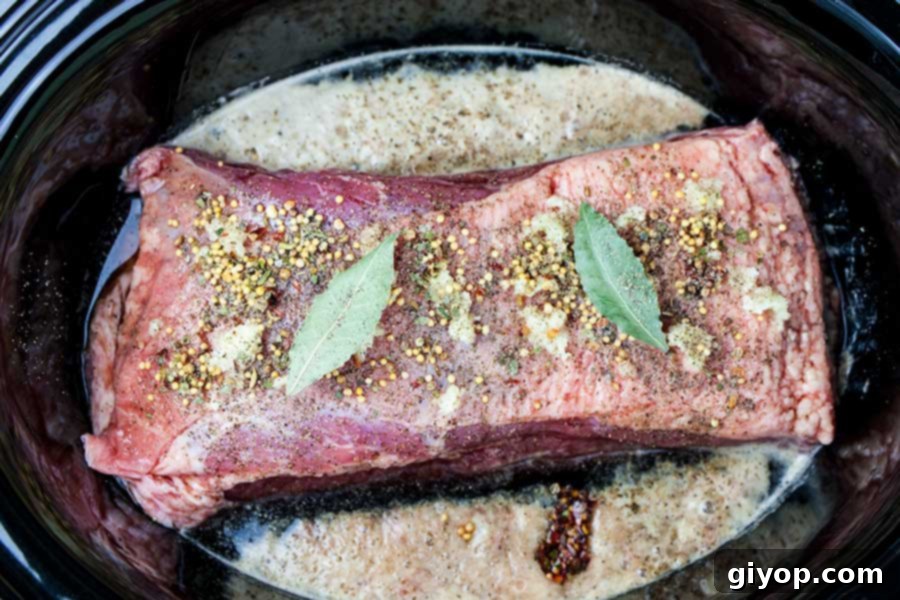 Melt-in-Your-Mouth Slow Cooker Corned Beef 3 Raw corned beef, spices, and liquids in the crock of the slow cooker.