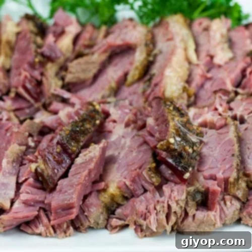 Melt-in-Your-Mouth Slow Cooker Corned Beef 7 Slow cooker corned beef on a platter garnished with parsley.