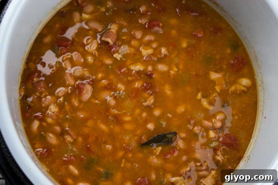 The Ninja Foodi pot filled with simmering Mexican Pinto Beans, showing the rich, soupy consistency just after pressure cooking and before thickening.