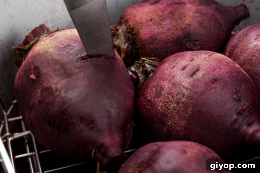 A cooked beet is being tested for tenderness with the tip of a sharp knife while still in the pressure cooker pot, illustrating the doneness check.