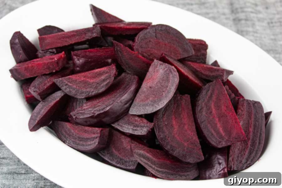 Beautifully sliced pressure cooker beets, piled high on a pristine white platter, showcasing their vibrant color and tender texture, ready to be served.