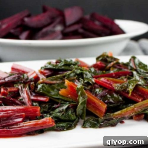 Ninja Foodi fresh beet greens on a white platter with fresh beets in the background.