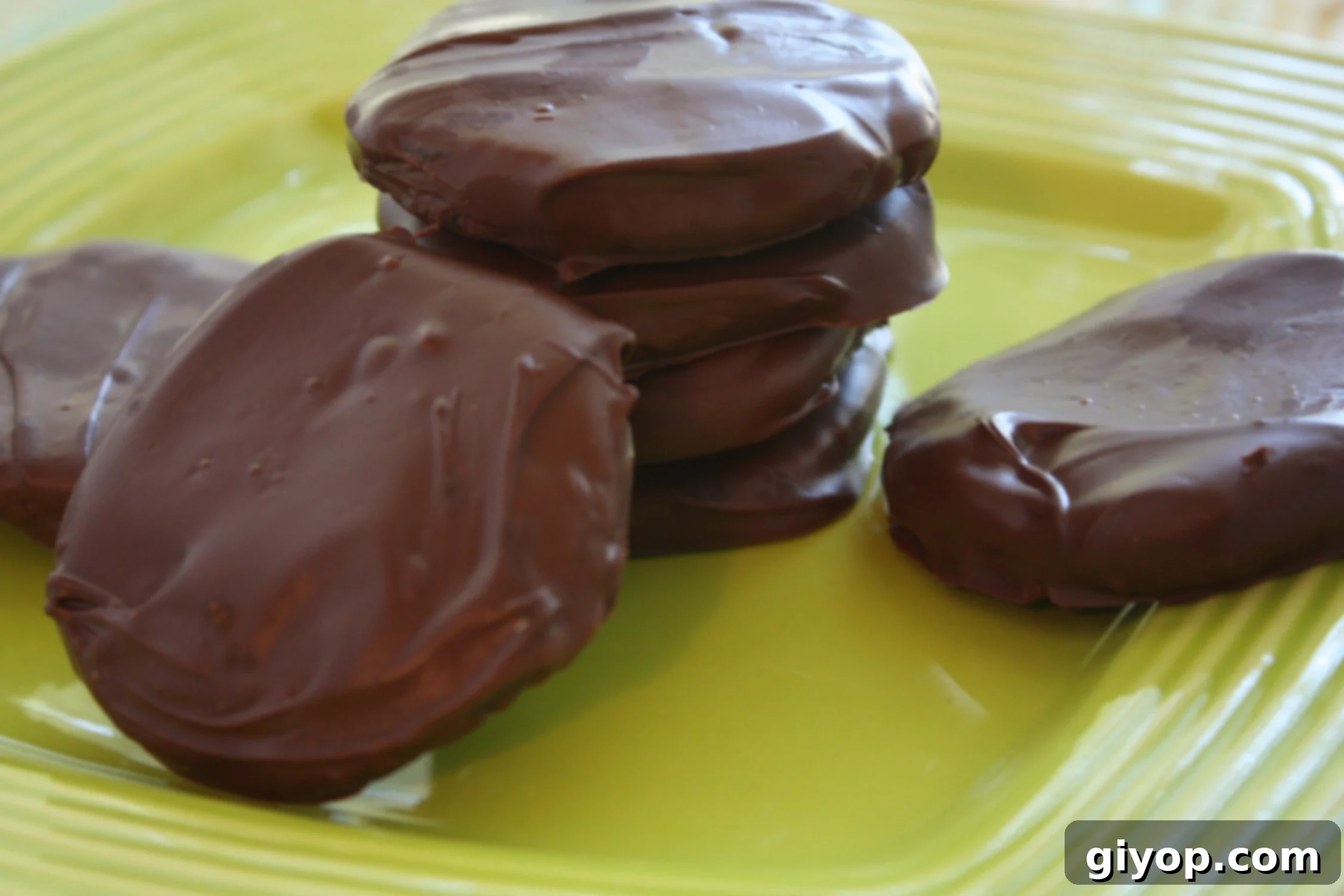 A plate of homemade Thin Mint cookies, perfectly coated in chocolate, ready to eat.