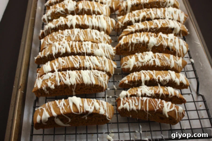 Autumn Spice Latte Biscotti 6 Golden brown Pumpkin Spice Latte Biscotti cooling on a wire rack set inside a baking pan, allowing air to circulate and ensure even cooling.