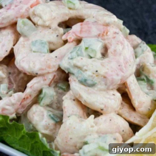 Shrimp Salad over lettuce leaves in a white bowl.