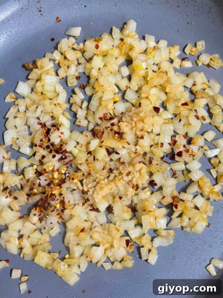 Ultimate Oven-Baked Spaghetti Delight 6 Chopped onions sautéing in a skillet, becoming translucent and soft.
