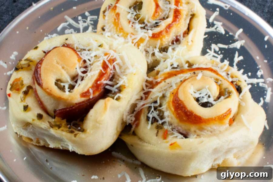 Muffuletta spirals on a silver plate garnished with parmesan cheese.