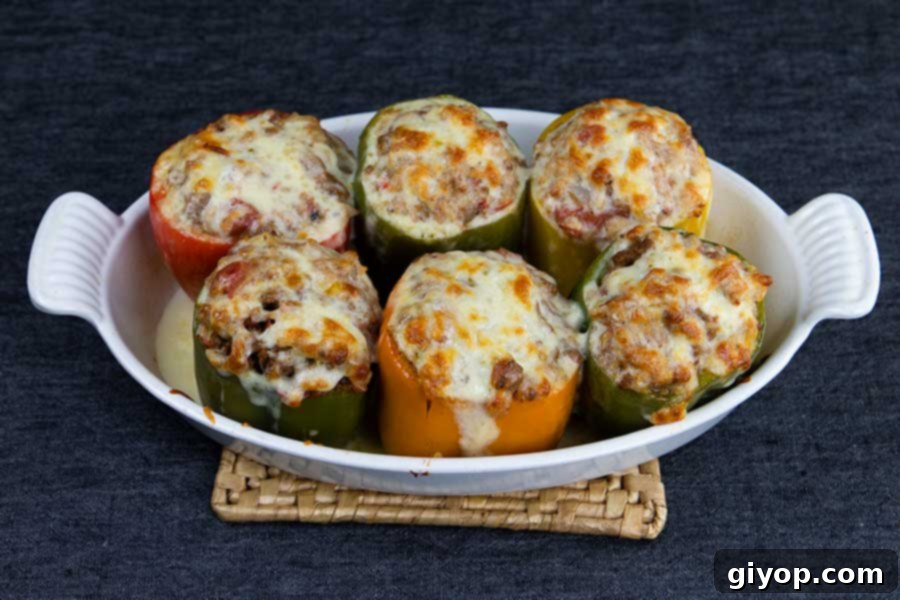 Cooked stuffed bell peppers in a white baking dish just removed from the oven.