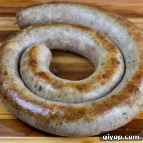 Cooked Italian sausage ring on a wooden cutting board.