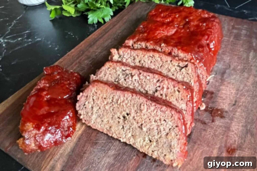 Slow-Smoked Meatloaf Masterpiece 3 sliced smoked meatloaf on a cutting board.