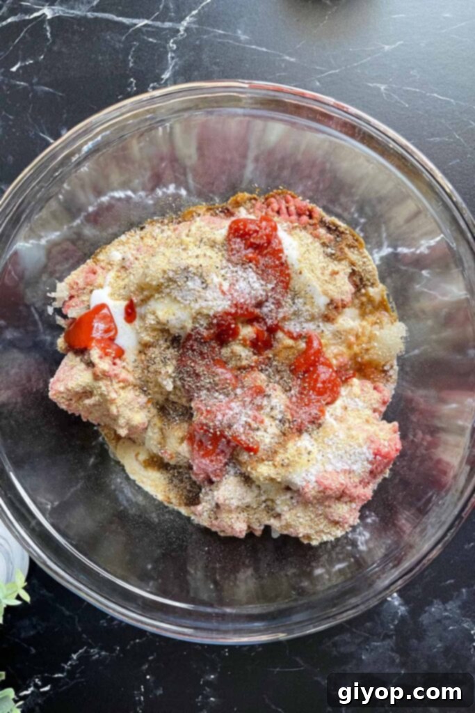 Slow-Smoked Meatloaf Masterpiece 5 meatloaf ingredients in a bowl waiting to be mixed together.