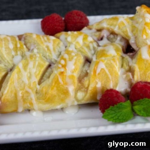 Raspberry Cream Cheese Swirl Danish 8 Raspberry cream cheese danish on a white platter garnished with fresh raspberries and mint.