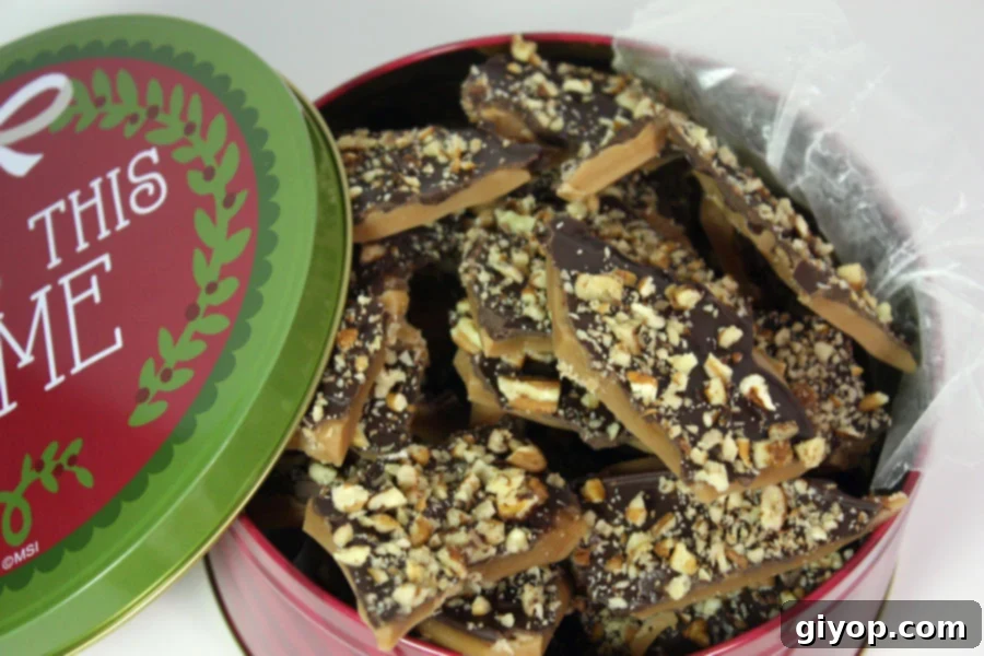 Homemade toffee pieces neatly arranged in a festive cookie tin.