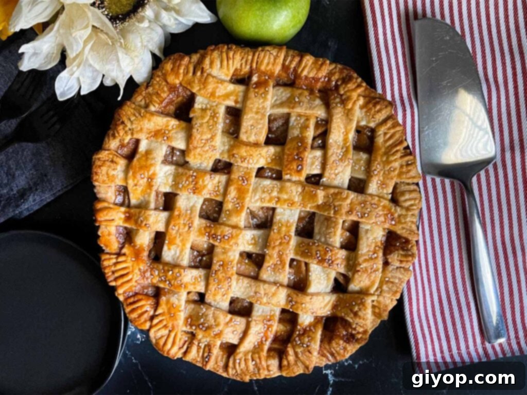 Classic lattice crust apple pie on a dark surface, golden brown and inviting.