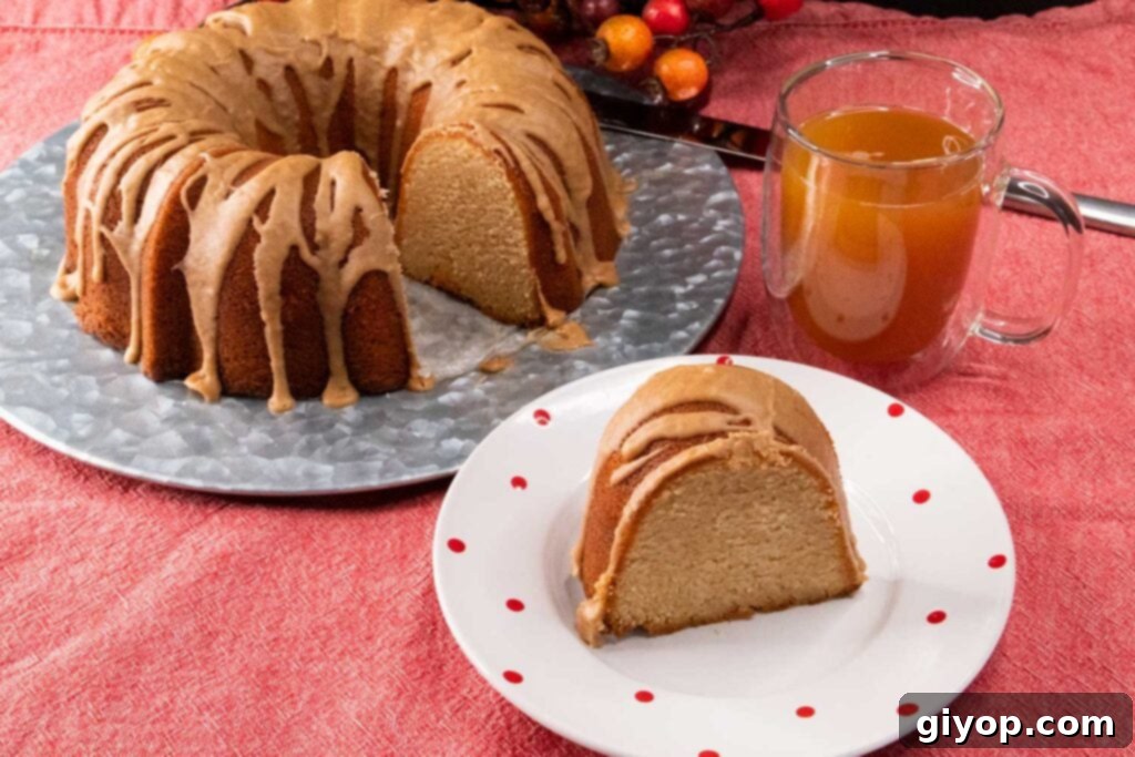 Cider-Glazed Apple Pound Cake 3 A perfectly sliced piece of apple cider pound cake with glaze on a white plate, showcasing its moist interior.