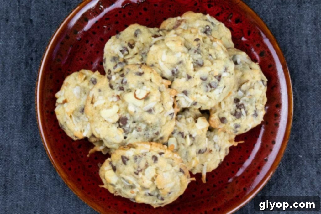 Freshly baked Almond Joy cookies neatly arranged on a vibrant red plate, garnished with extra chocolate chips and coconut flakes.