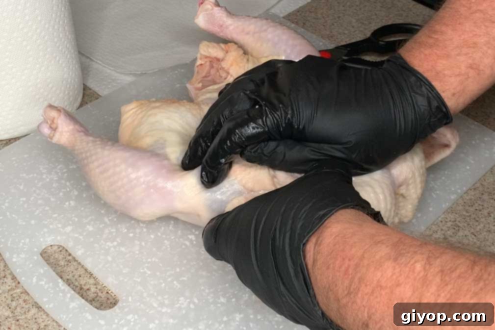 Cracking the breastbone of a chicken to flatten it for spatchcock cooking.