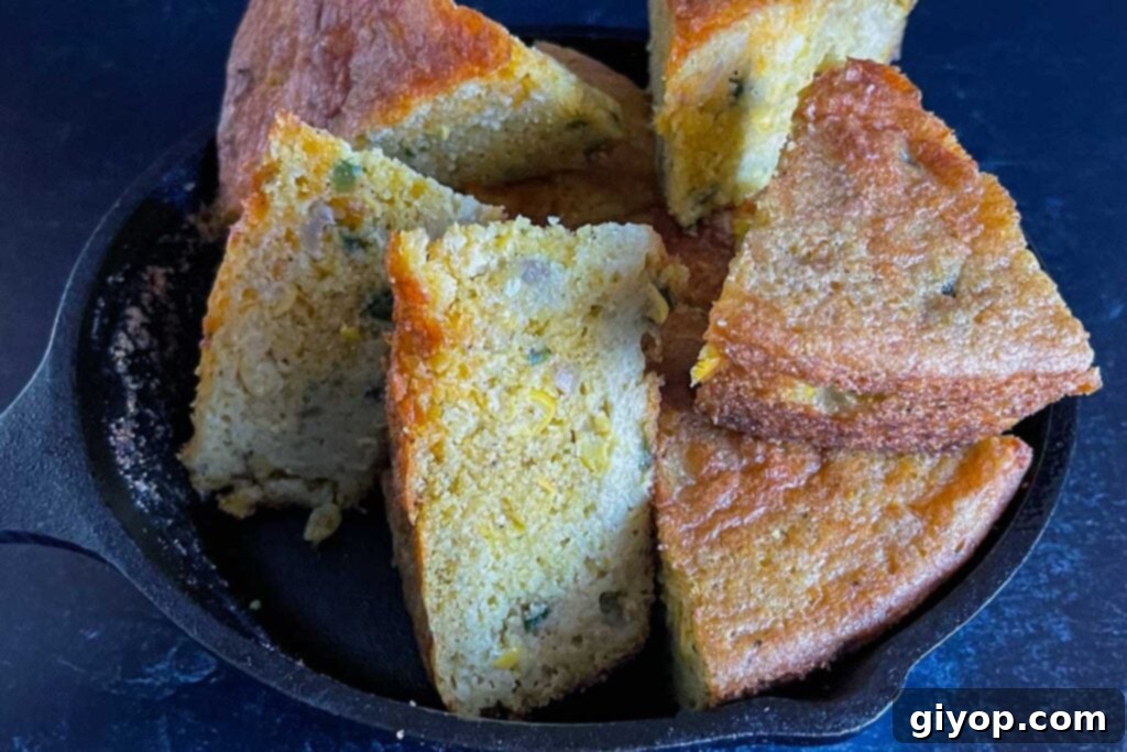 Creole cornbread slices stacked in a cast iron skillet.