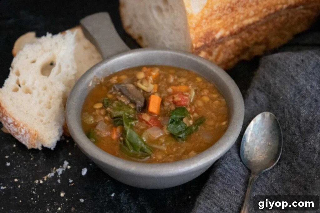 Slow cooker lentil soup with a loaf of bread.