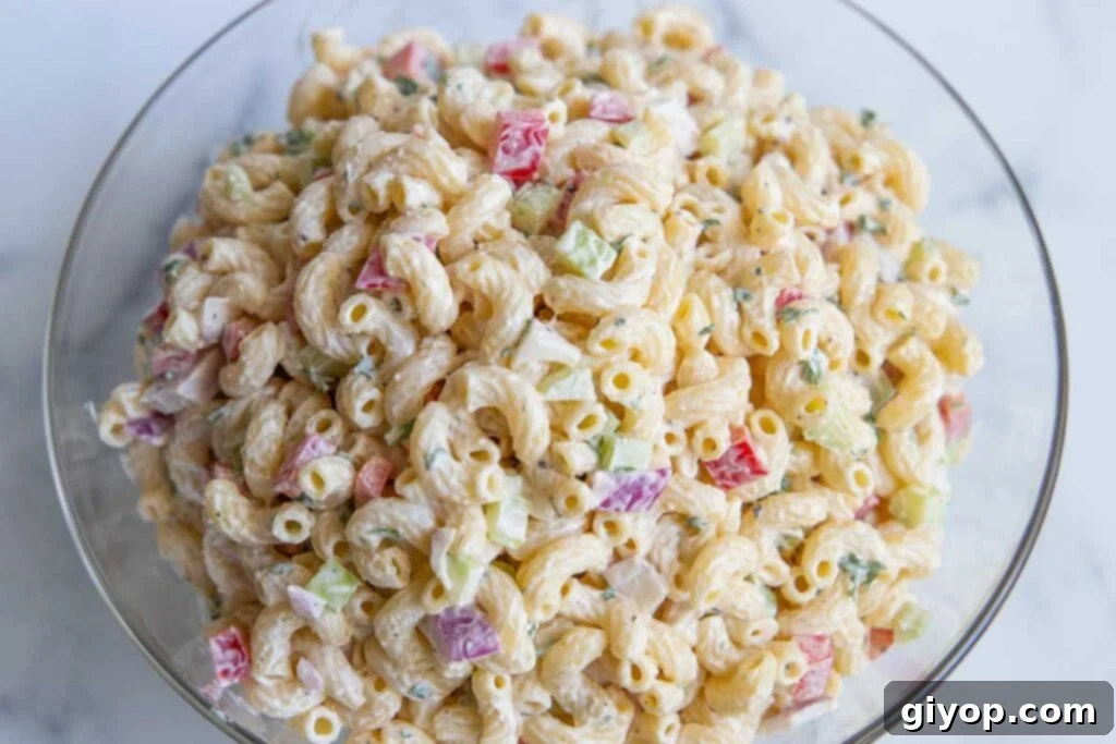 A close-up view of homemade macaroni salad, perfectly dressed and ready to be served in a stylish glass bowl.