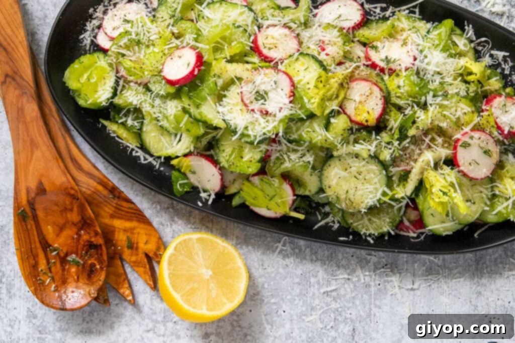 Crisp cucumber radish salad beautifully arranged on a black platter, garnished with fresh dill and cheese.