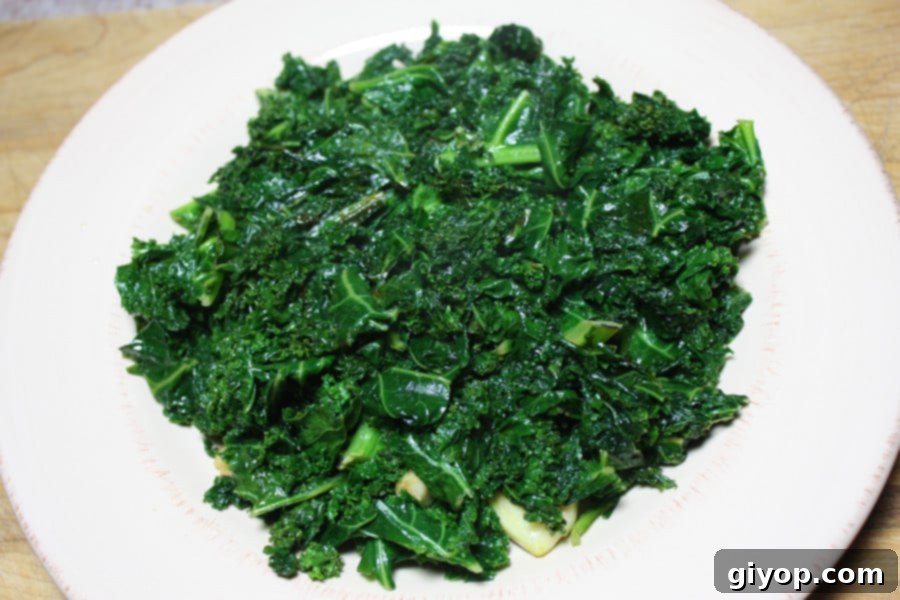 Vibrant green sautéed kale served in a white bowl, ready to be enjoyed as a healthy and flavorful side dish.