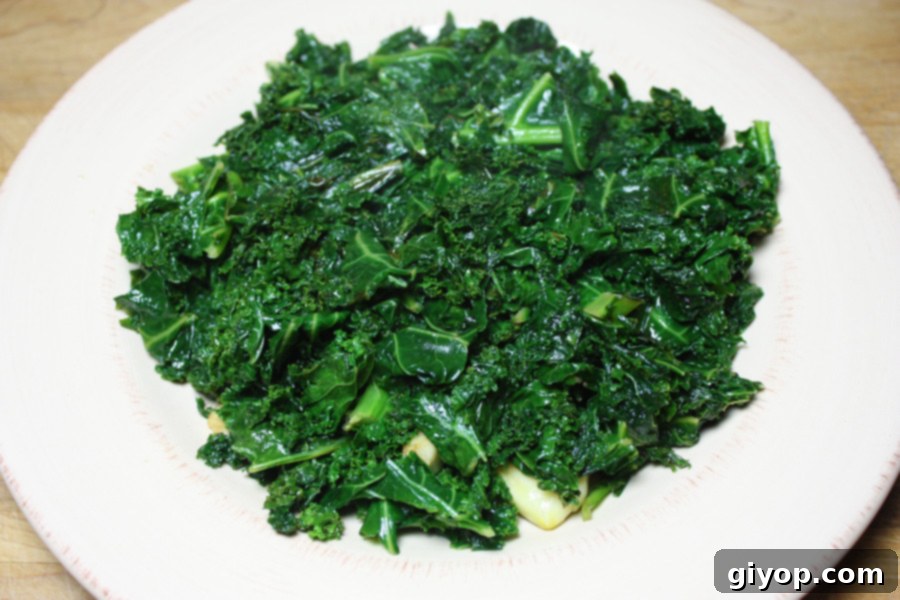 Close-up of a serving of sautéed kale in a white bowl.