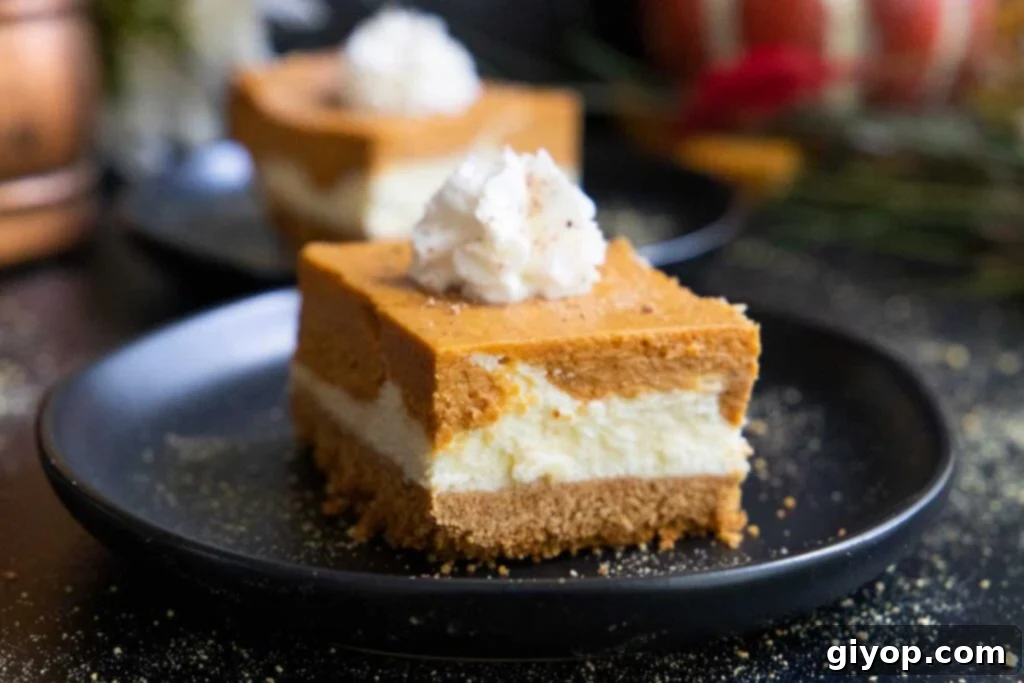 A perfectly sliced pumpkin cheesecake bar, showcasing its distinct layers, resting elegantly on a black plate.