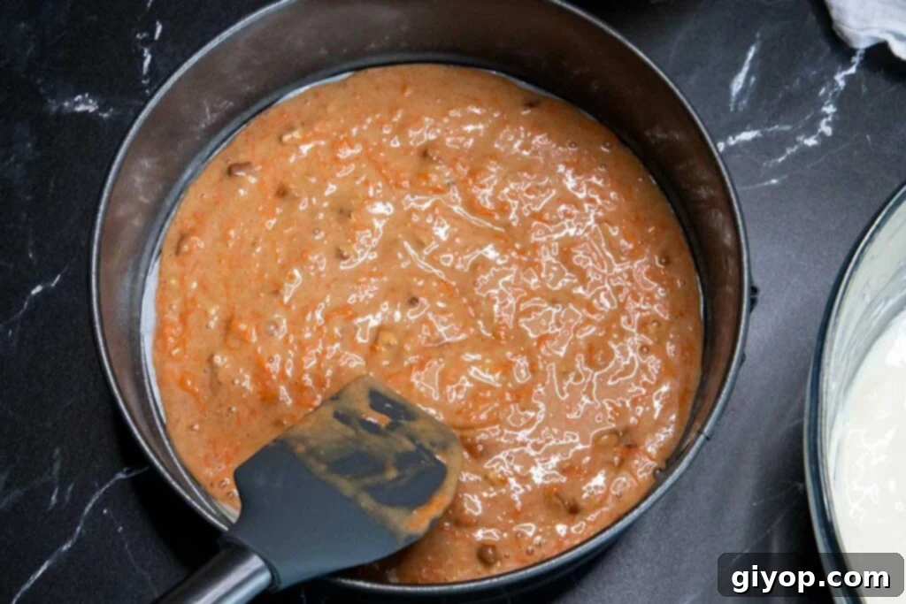 Carrot cake batter spread as the first layer in a springform pan.