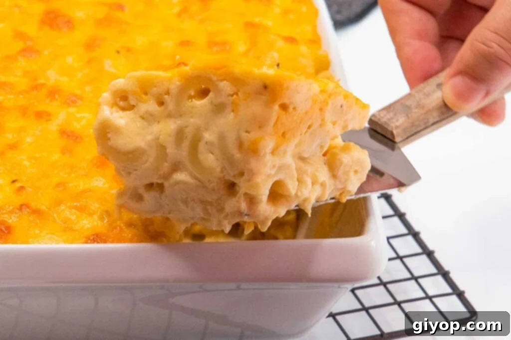 Getting a portion of baked macaroni and cheese out of the baking dish.