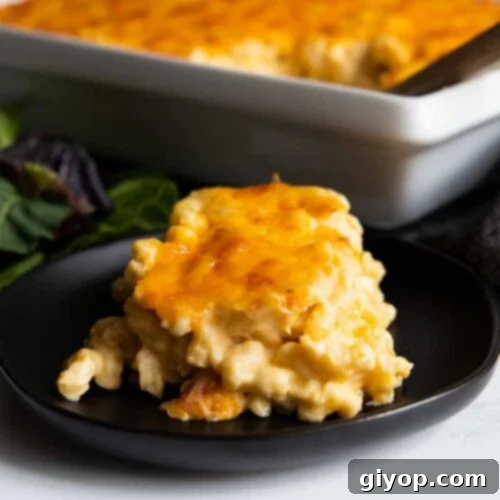 A serving of macaroni and cheese on a black plate.