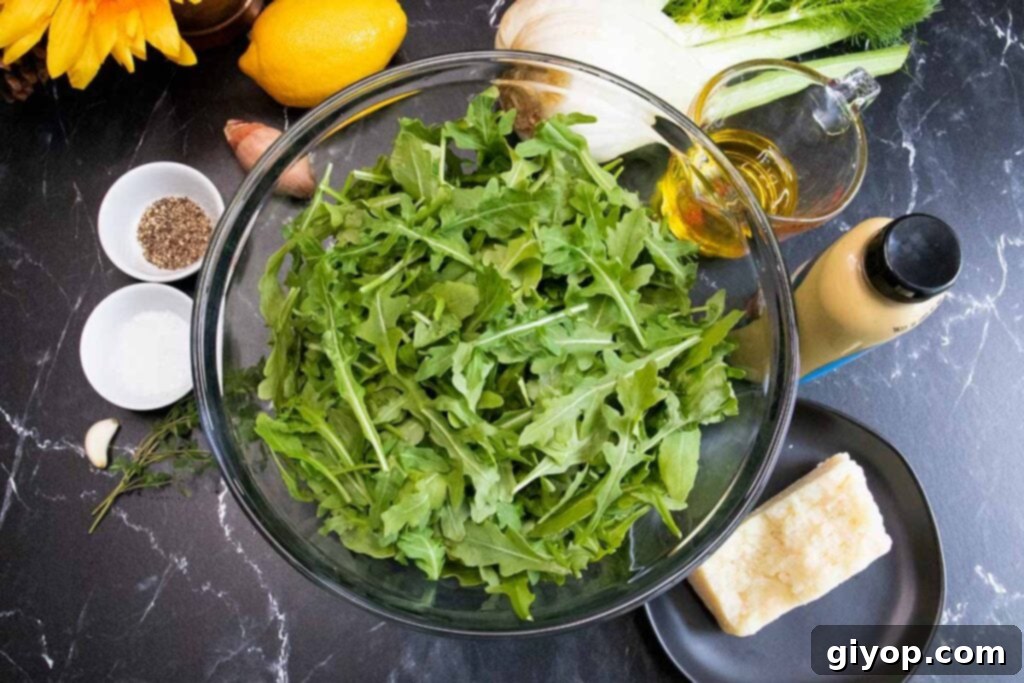 Zesty Arugula Fennel Medley 4 A flat lay showing all the fresh salad ingredients laid out on a cutting board, including arugula, fennel, lemon, shallot, and cheese.