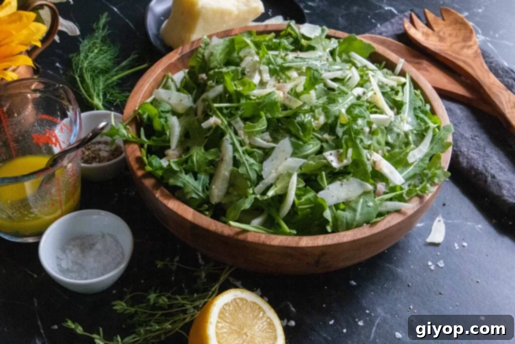 Zesty Arugula Fennel Medley 5 A close-up shot of the finished arugula fennel salad with shaved cheese on top in a wooden bowl.