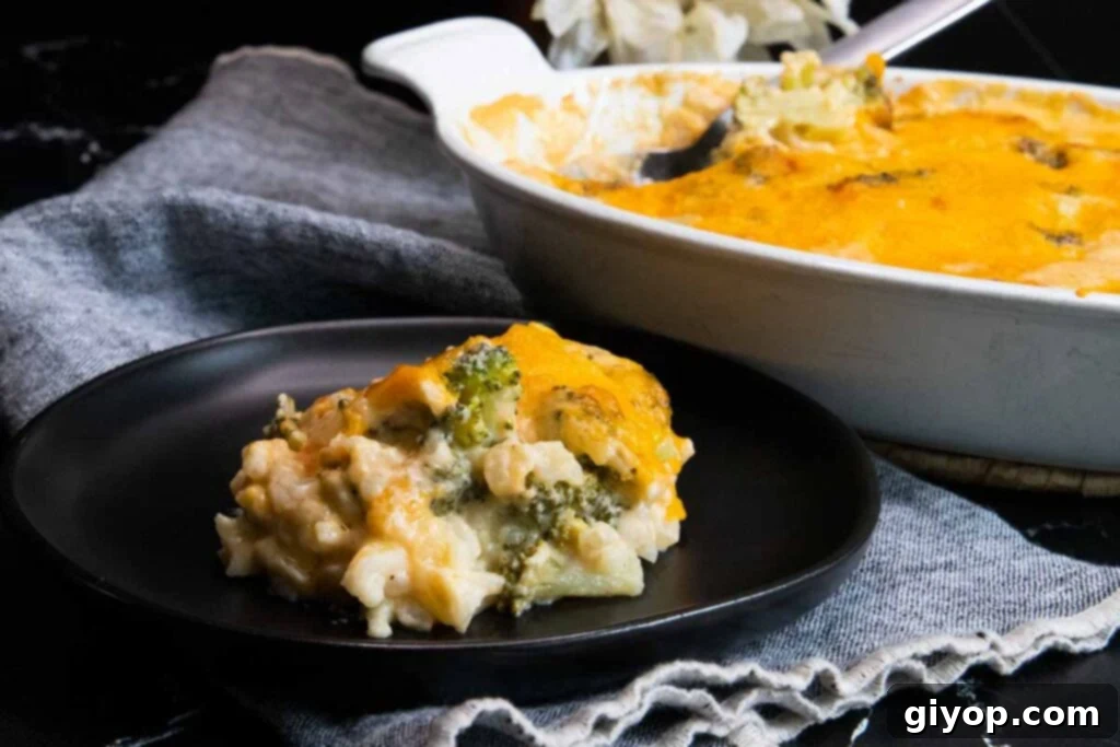 Broccoli rice casserole on black plate, showcasing its golden-brown topping and creamy texture.