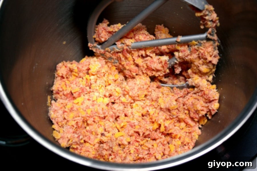 Sausage ball mixture in the bowl of a stand mixer.