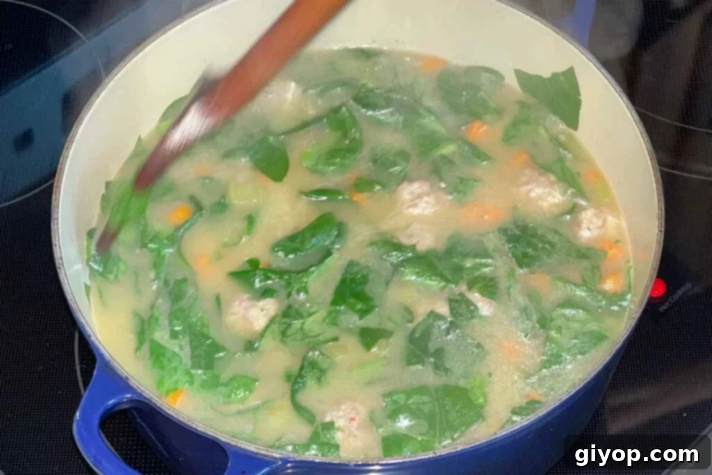 Spinach being stirred to the pot.
