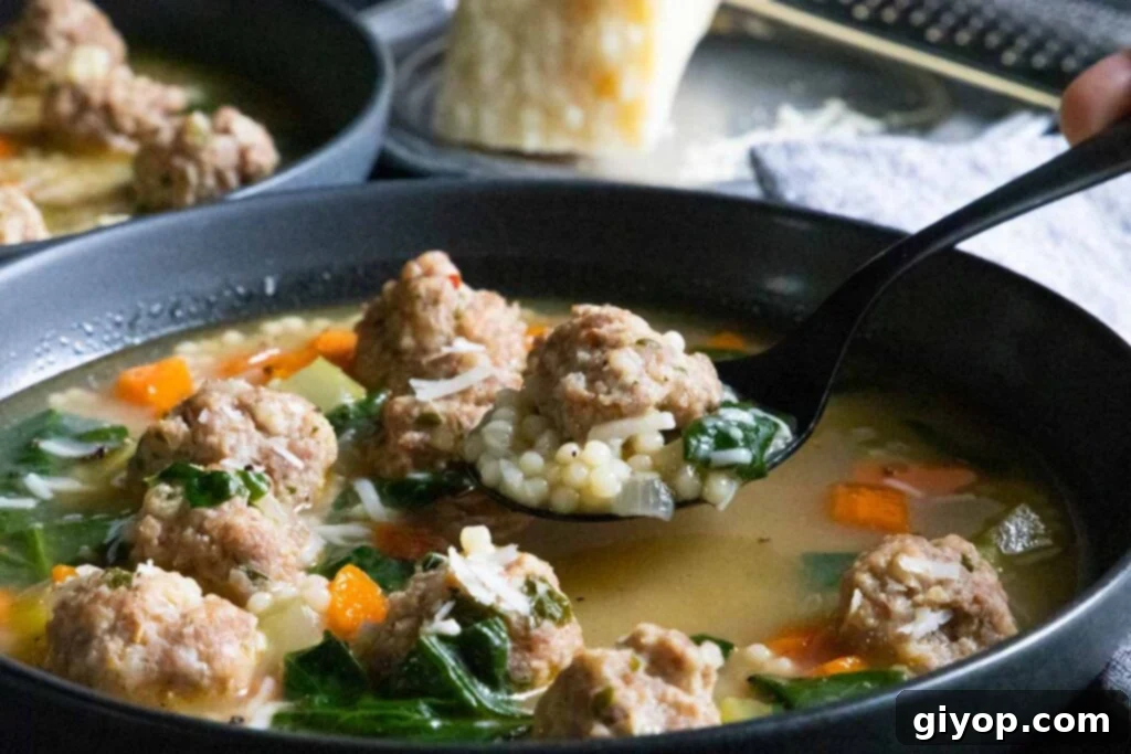 Wedding soup on a black spoon.