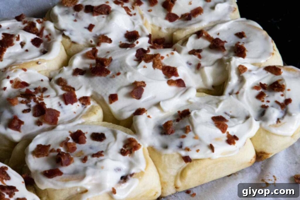 Maple bacon cinnamon rolls arranged beautifully on parchment paper atop a wooden board, ready to be enjoyed.