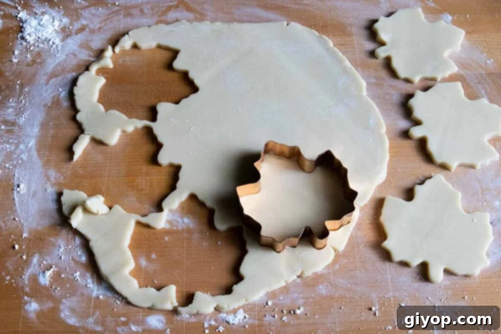 Maple Glazed Shortbread Perfection 4 Maple leaf-shaped cookie dough cut out and arranged on a wooden board, ready for baking.