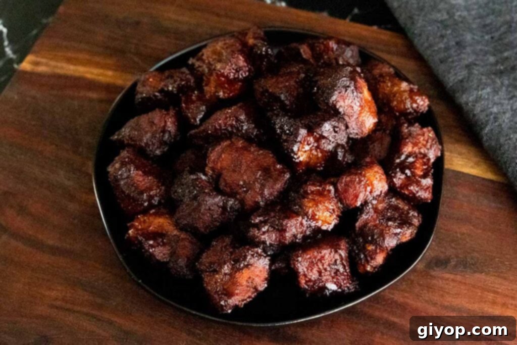 Ultimate Smoked Pork Burnt Ends 17 Pork butt burnt ends on a black plate
