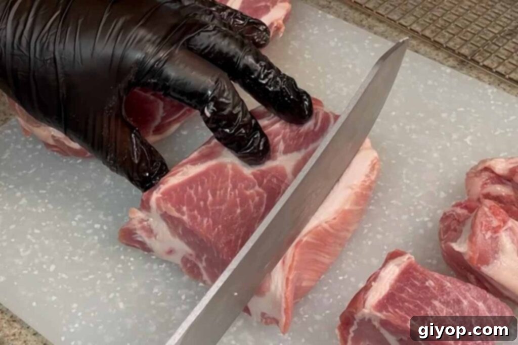 Ultimate Smoked Pork Burnt Ends 4 trimming fat away from a piece of pork butt