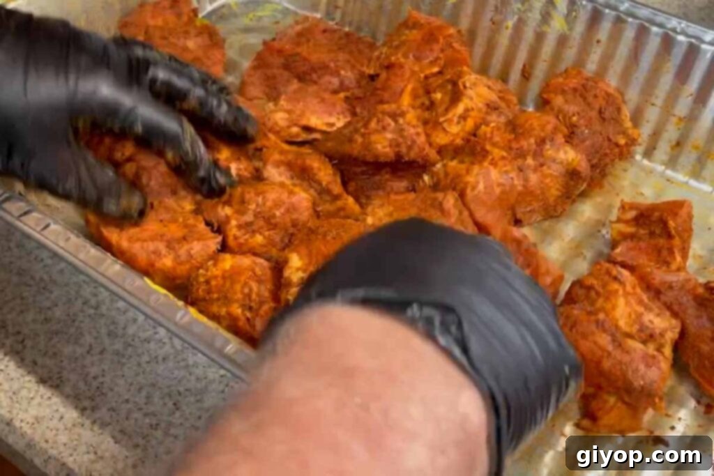 Ultimate Smoked Pork Burnt Ends 8 applying rub to pork butt cubes