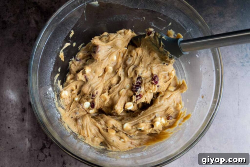 Blondie dough in a glass mixing bowl, ready to be spread into the pan.