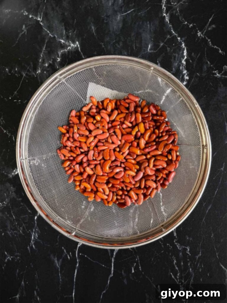 Soulful Slow Cooker Red Beans and Rice 4 Red beans in a strainer on a dark surface.