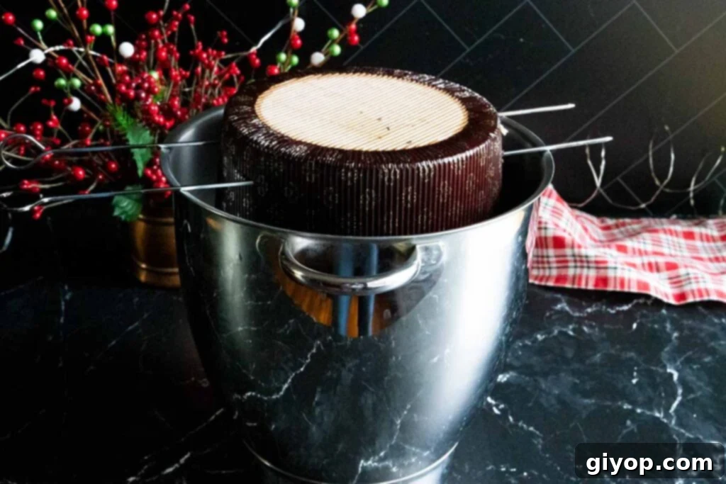 Decadent Chocolate Orange Panettone 19 Baked panettone hanging upside down in a mixing bowl to cool.