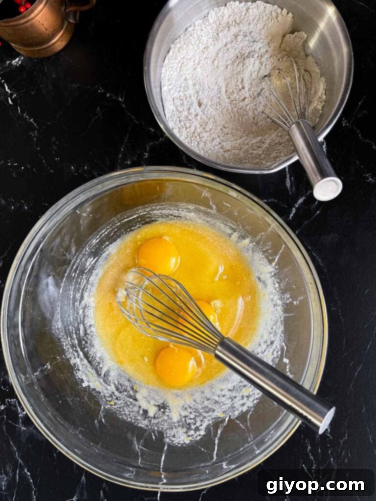 Eggs added to the wet ingredients for the cranberry pistachio biscotti in a glass bowl.