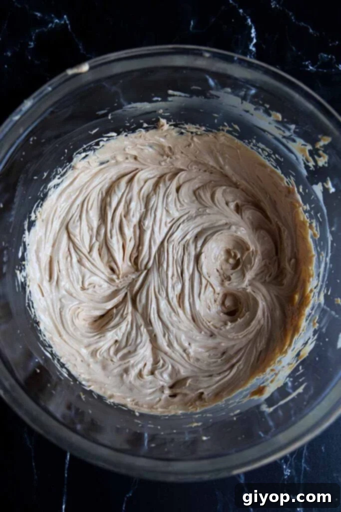 Shortening, butter, and peanut butter creamed together in a glass mixing bowl.