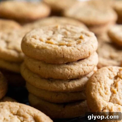 Peanut butter cookies on a wire rack in a baking sheet.